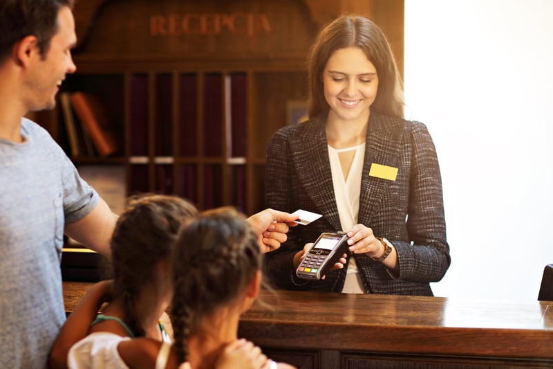 happy-family-checking-in-hotel-at-reception-desk-2025-01-07-23-18-33-utc